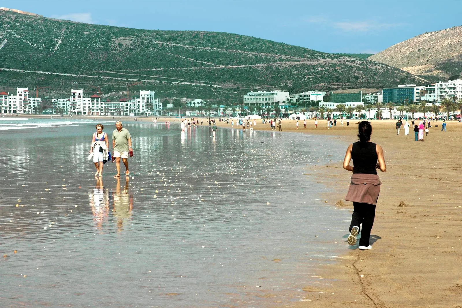 Longue plage d'Agadir et sa promenade bordée de palmiers, vue de la baie