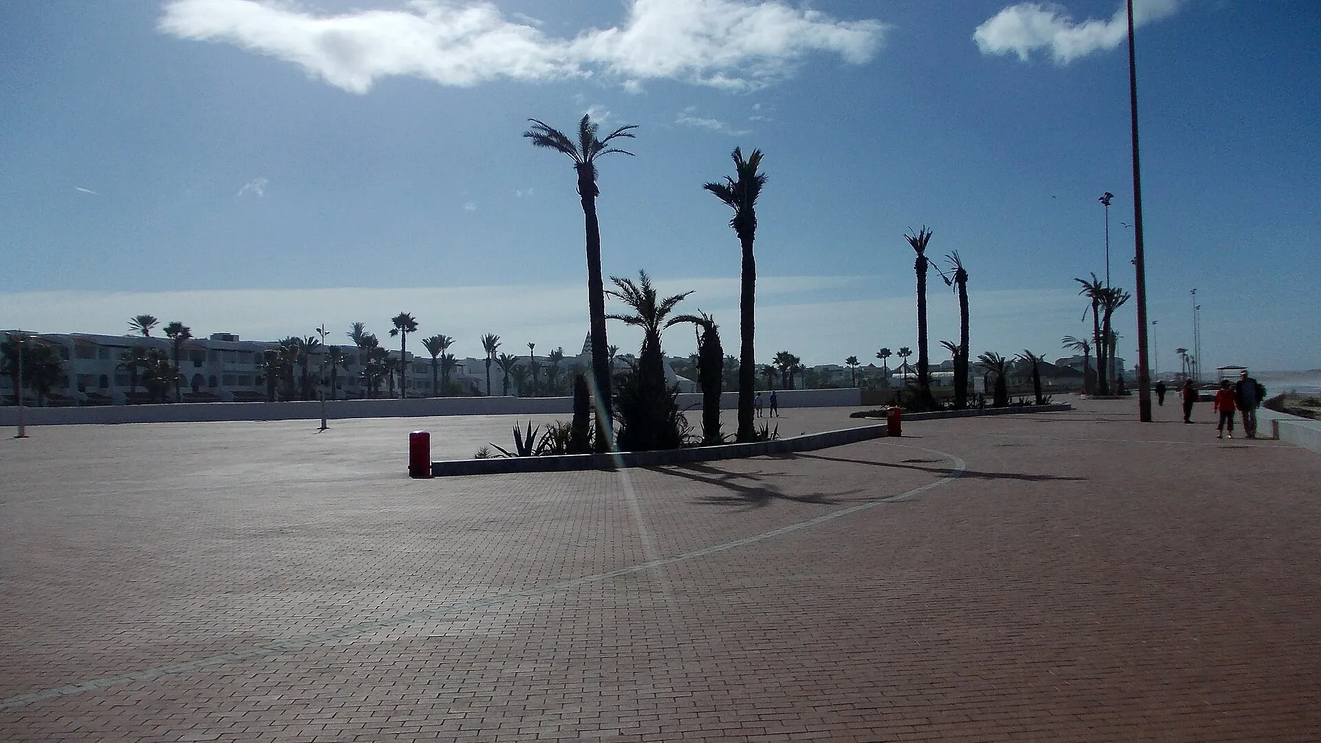 Longue plage d'Agadir au Maroc avec promenade et palmiers, vue de la baie