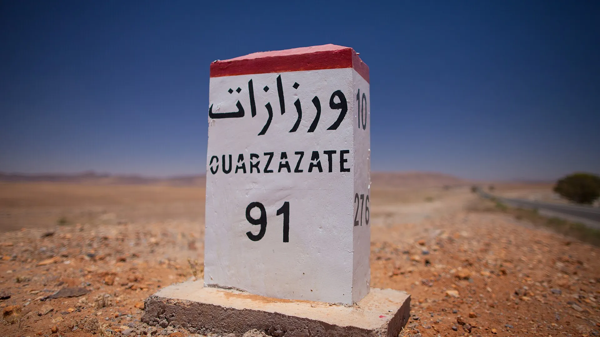Camping-car parqué en bord de route dans le sud marocain, lumière de fin de journée