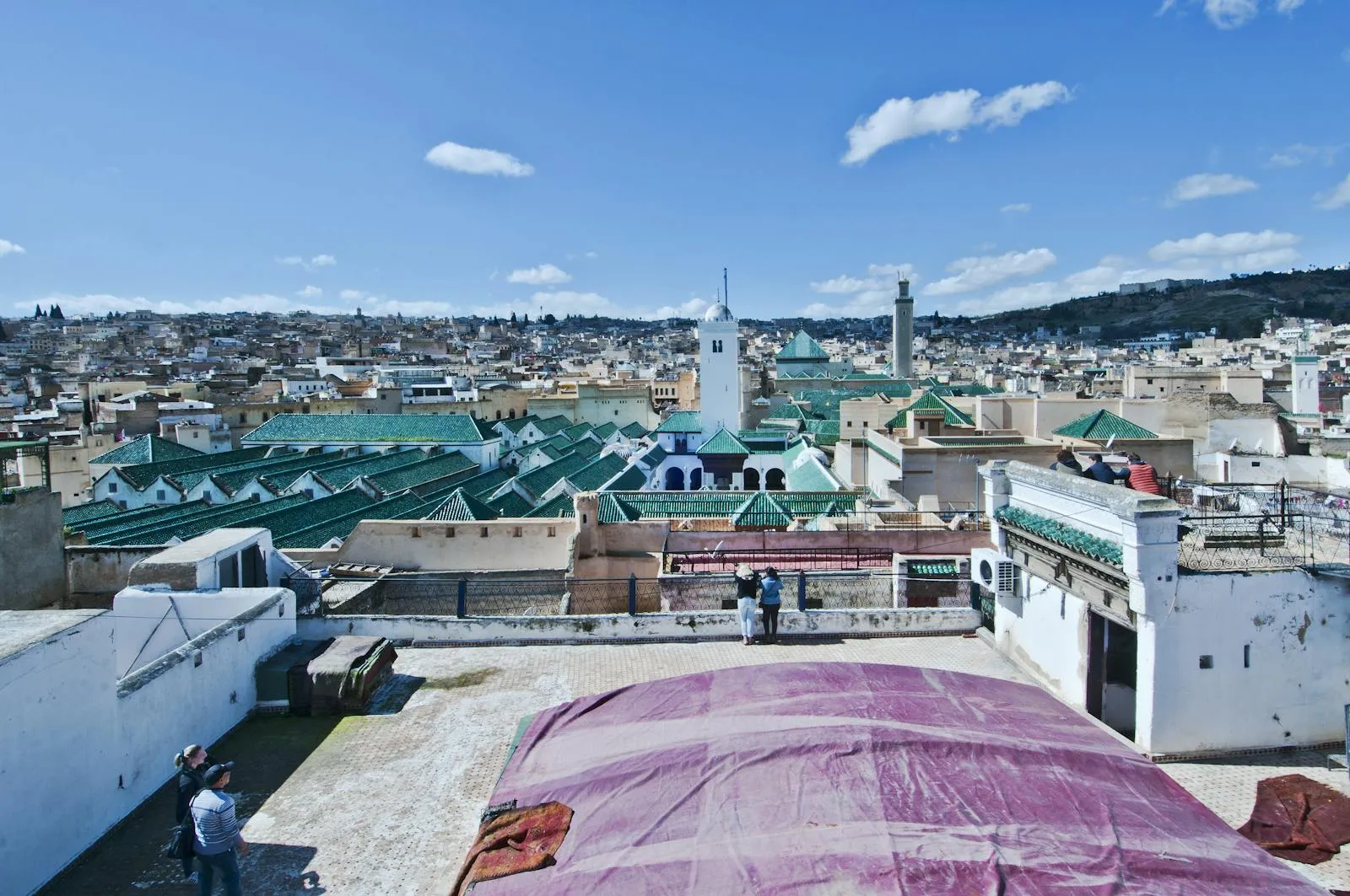 Vue panoramique sur la médina de Fès depuis un toit, minarets et tuiles vertes