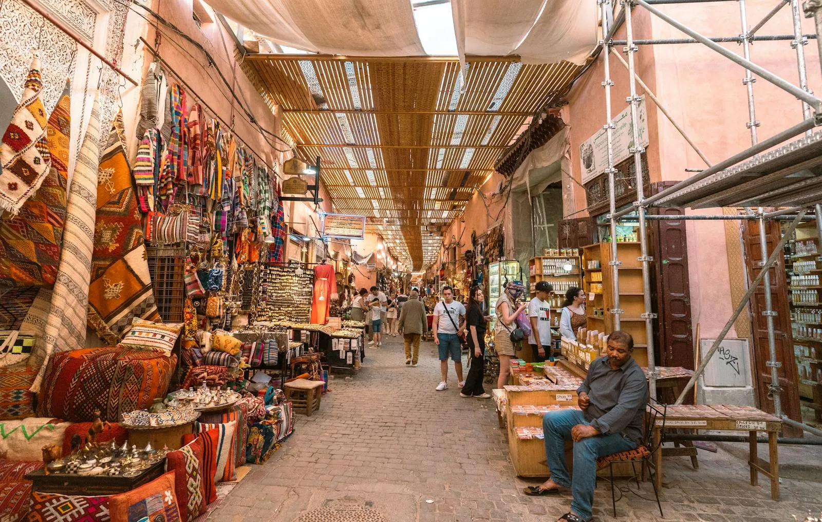 Souks colorés de la médina de Marrakech avec étals d'épices et tissus traditionnels marocains
